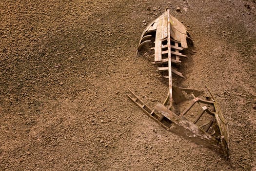 boat ship skeleton grunge half buried in brown sand