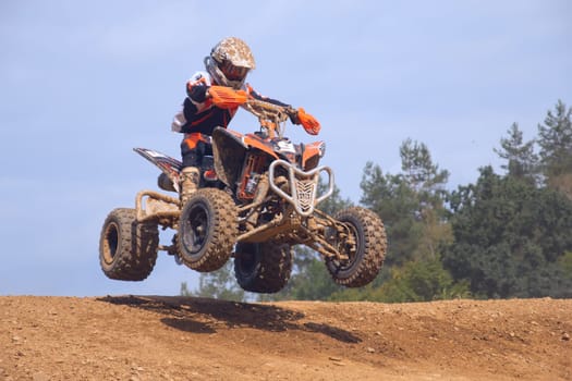 MOHELNICE,  CZECH REPUBLIC - SEPTEMBER 08: Unidentified teen racer jumps a quad motorbike in the "International Championship of the Czech Republic 2012"" on September 08, 2012 in MOHELNICE, Czech Republic."