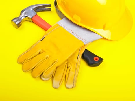 Worker equipment - HardHat Hammer And Leather Gloves on yellow
