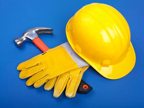 Worker equipment - HardHat Hammer And Leather Gloves on Blue