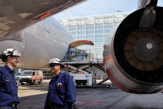 two airplane mechanics with large jet engines, airport maintenance