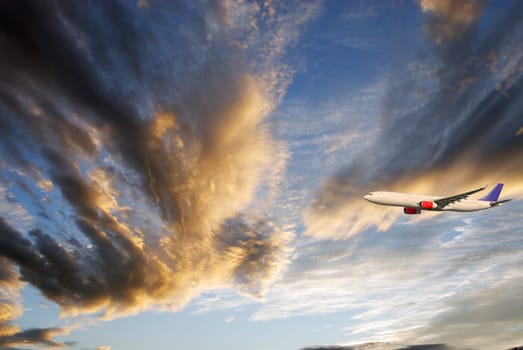 airplane, airliner flying into a dramatic sunset cloud scape