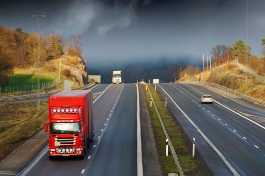 trucks driving through a misty and foggy mountain-pass, elevated view