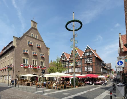 people enjoying the sun on a terrace in the center of Munster, Germany. The city is considered to be the cultural center of the Westphalia region. It is also capital of the local government region Münsterland.