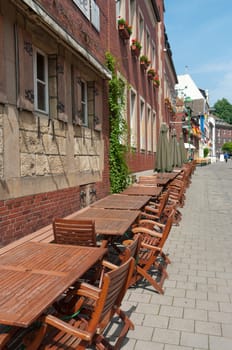 typical german street terrace with large wooden tables and chairs in Munster, Germany