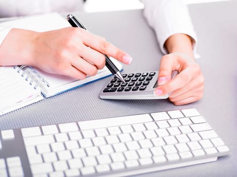 Office business woman calculating with calculator and pencil