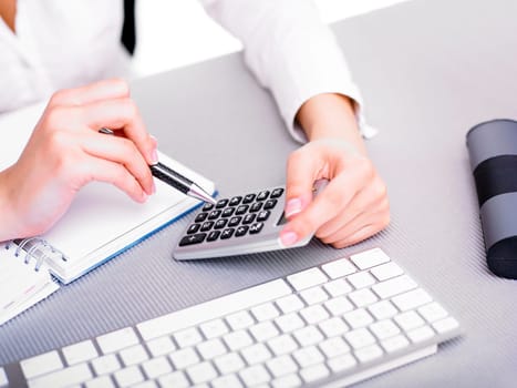 Office worker woman calculating with calculator
