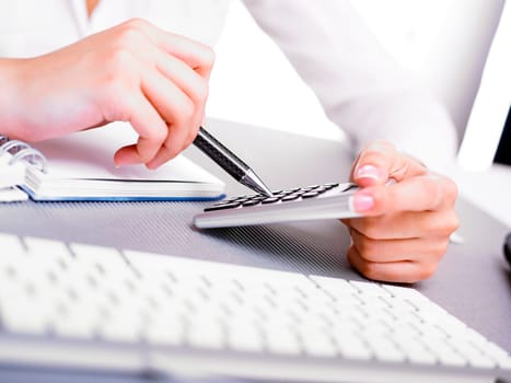 Office business woman calculating with calculator and pen