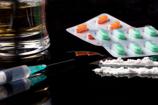 drugs and pills on black background with reflection