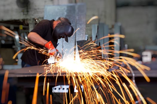 sparks frying over the working table during metal grinding