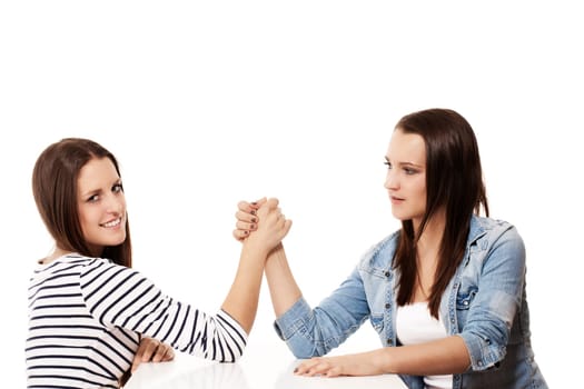 Teenager wrestling arms against white background