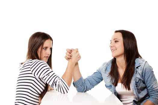 Female teenage arm wrestling in front of white background