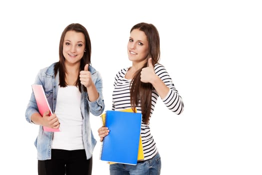 Two schoolgirls show thumbs up in front of white background