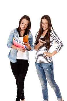 Two students busy with smartphone and exercise books against white background