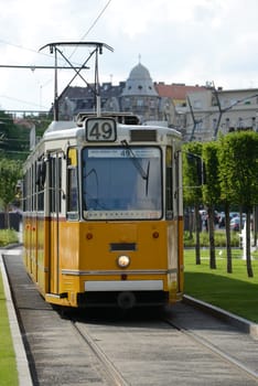 Typical articulated yellow tram approaching in Budapest (Hungary).