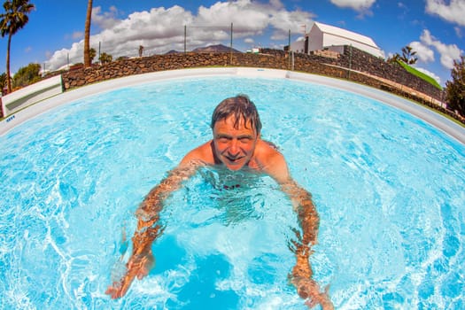 smart man enjoys swimming in the pool