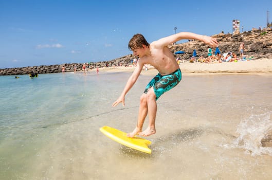 happy boy enjoys surfing in the waves at the beach