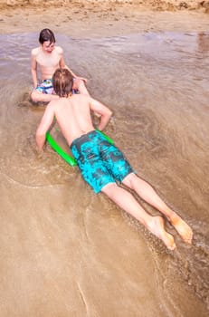 happy boy enjoys surfing in the waves at the beach