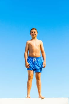 cute boy posing on a roof of a pool