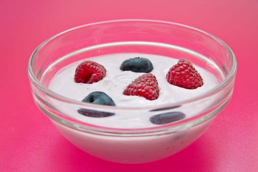 Jogurt glass bowl with fresh raspberries and blueberries