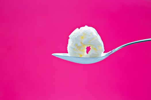 Tasty icecream on metal chromed spoon on background