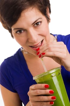 Beautiful woman with manicured nails sips a green smoothie