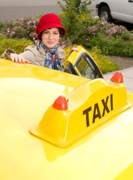 Beautiful woman enters a yellow taxi