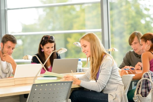 High-school students studying in library together academic teenagers study