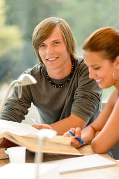 Teens reading book studying in high-school library campus young students