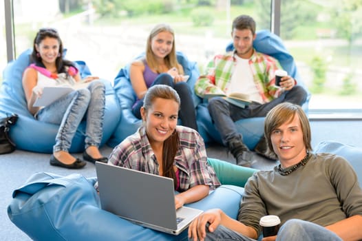 Students sitting on beanbags study room high-school teens happy