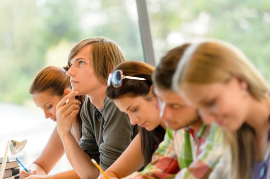 High-school student thinking at exam class teens writing college study
