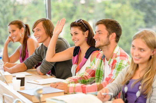 High-school student raising her hand in class lesson teenagers study