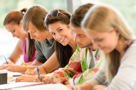 Students writing at high-school exam teens study campus academic class