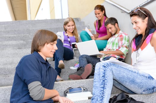 Students relaxing on high-school steps in break teens young college