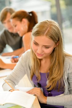 High-school student taking notes in library study academic campus teenager