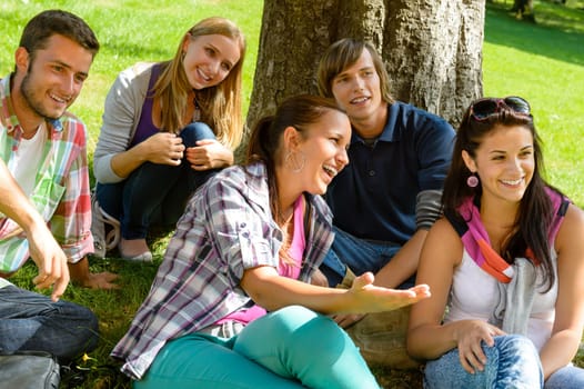 Students relaxing in schoolyard teens meadow park laughing campus young