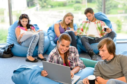 Students sitting on beanbags study room high-school teens happy