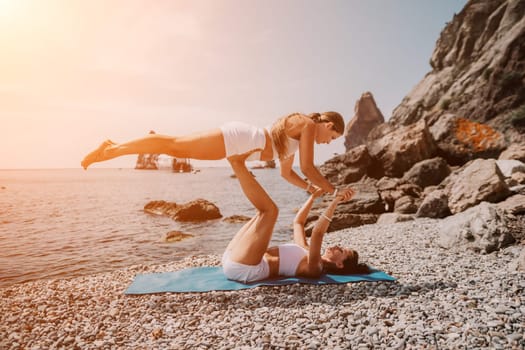 Woman sea yoga. Back view of free calm happy satisfied woman with long hair standing on top rock with yoga position against of sky by the sea. Healthy lifestyle outdoors in nature, fitness concept.