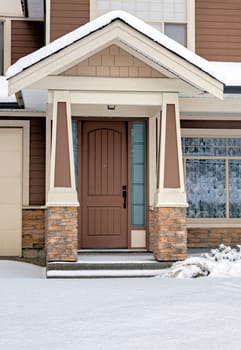 Entrance door of residential house in brown colors on winter day