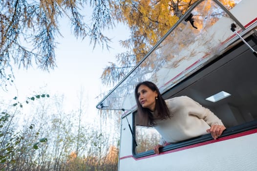 Caucasian woman peeking out of camper window