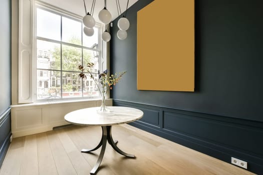 a room with blue walls and wood flooring, including a white round dining table surrounded by two hanging lamps