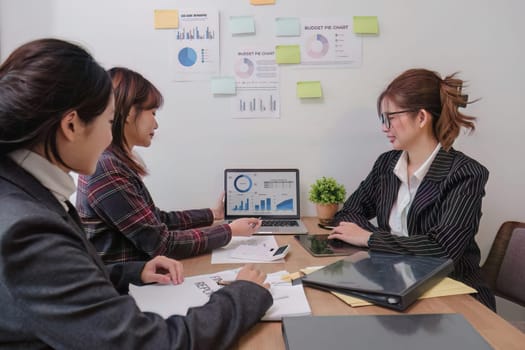 Business People Meeting using laptop computer,calculator,notebook,stock market chart paper for analysis Plans to improve quality next month. Conference Discussion Corporate Concept..