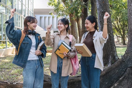 Group of cheerful Asian college students expressing happiness or friends Laughing together while sitting on campus.