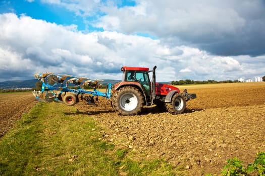tractor with plow on field in bad weather