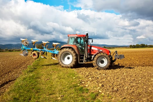 tractor with plow on field in bad weather