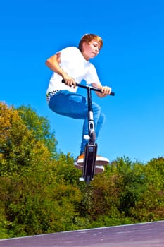 boy jumping with his scooter