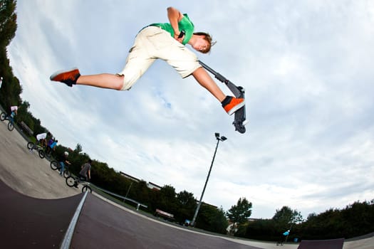cute boy jumping in the air with his scooter