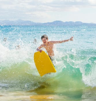 boy has fun surfing in the waves
