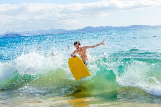 boy has fun surfing in the waves
