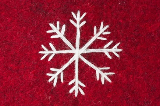 close-up of red felt with embroidered white snowflake